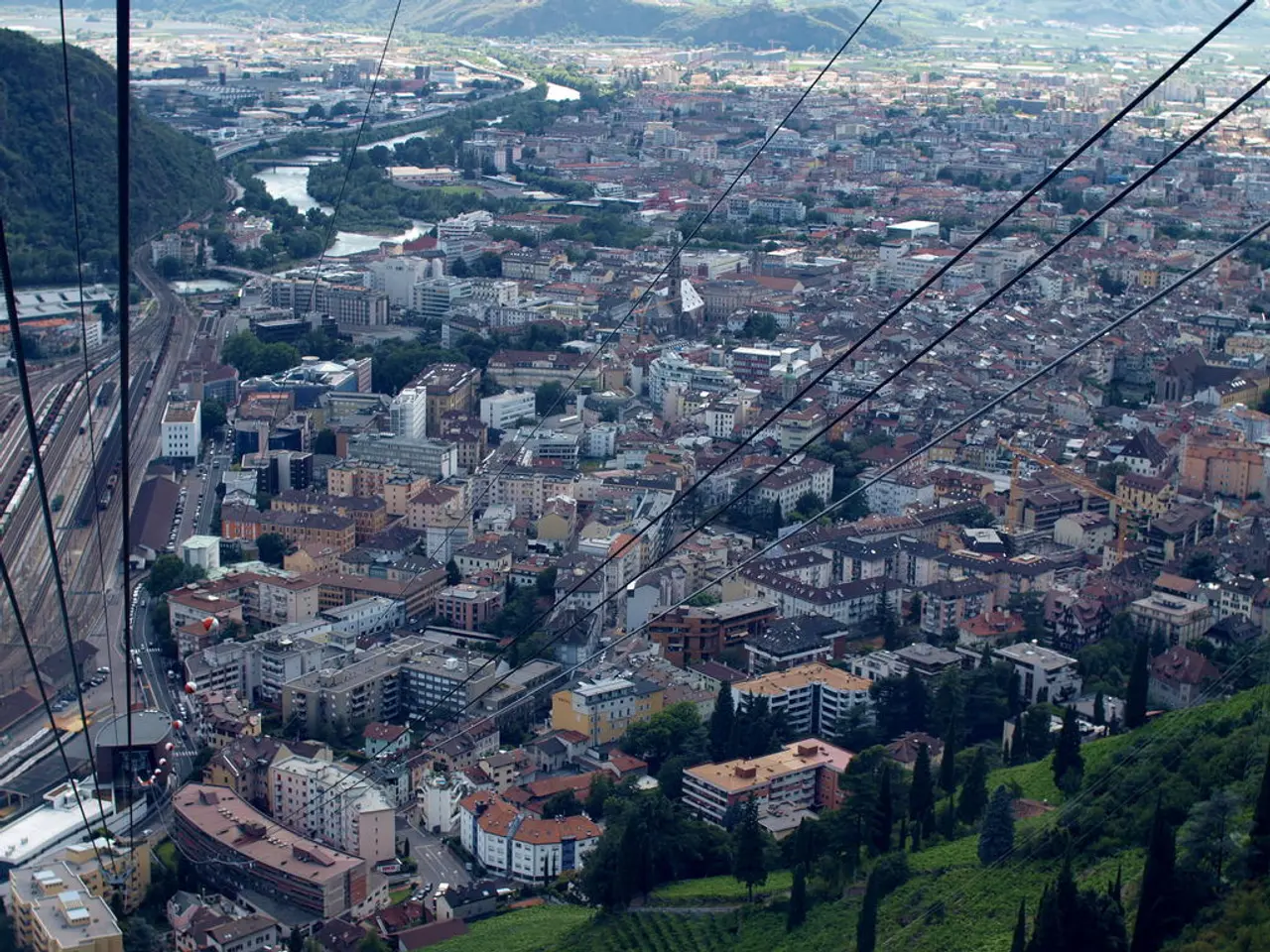 In the center of the image there are many buildings. There are trees. There is a mountain. There...