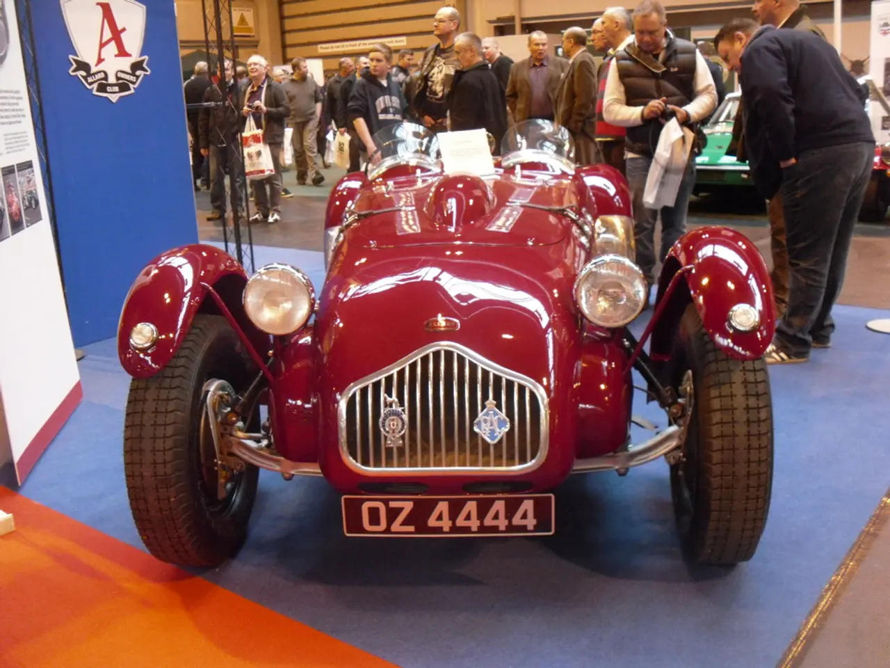 In the image there is a vehicle kept for an expo and on the left side there are two banners, around...