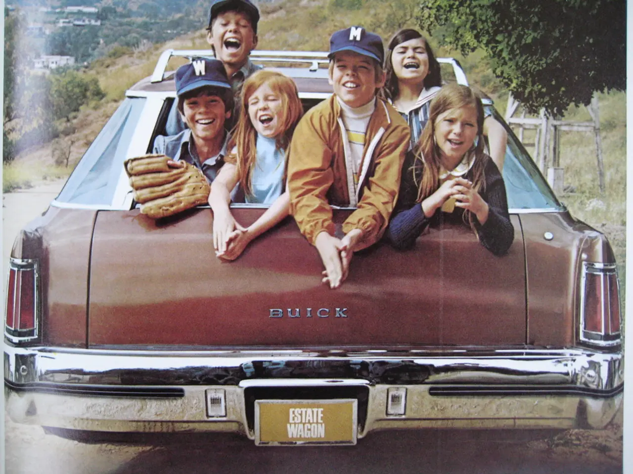 In this image I can see a group of children are sitting in a car and the children are smiling.