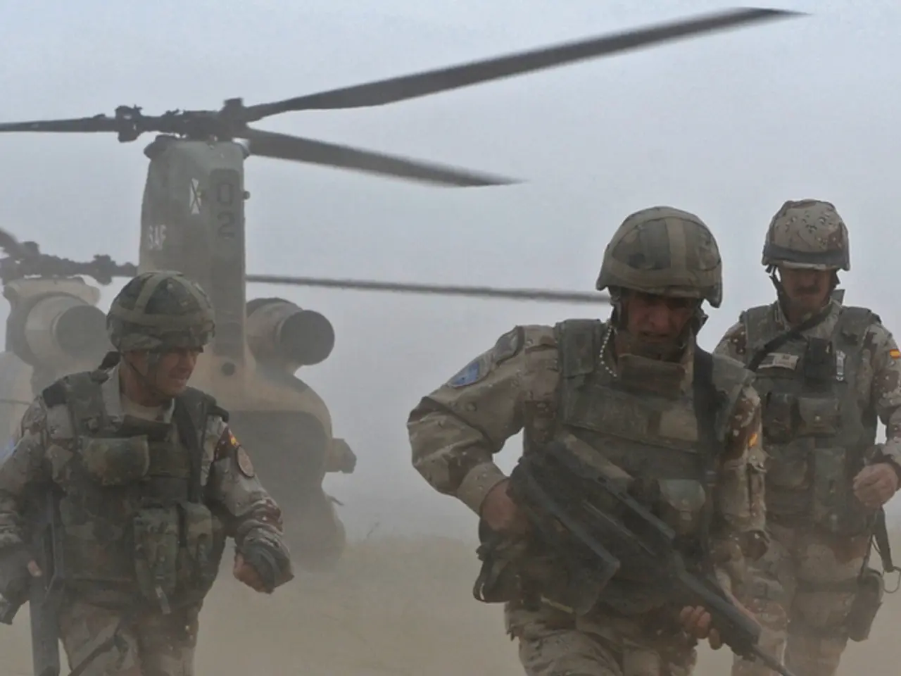 In this picture there are three persons holding the guns and running. At the back there is a...