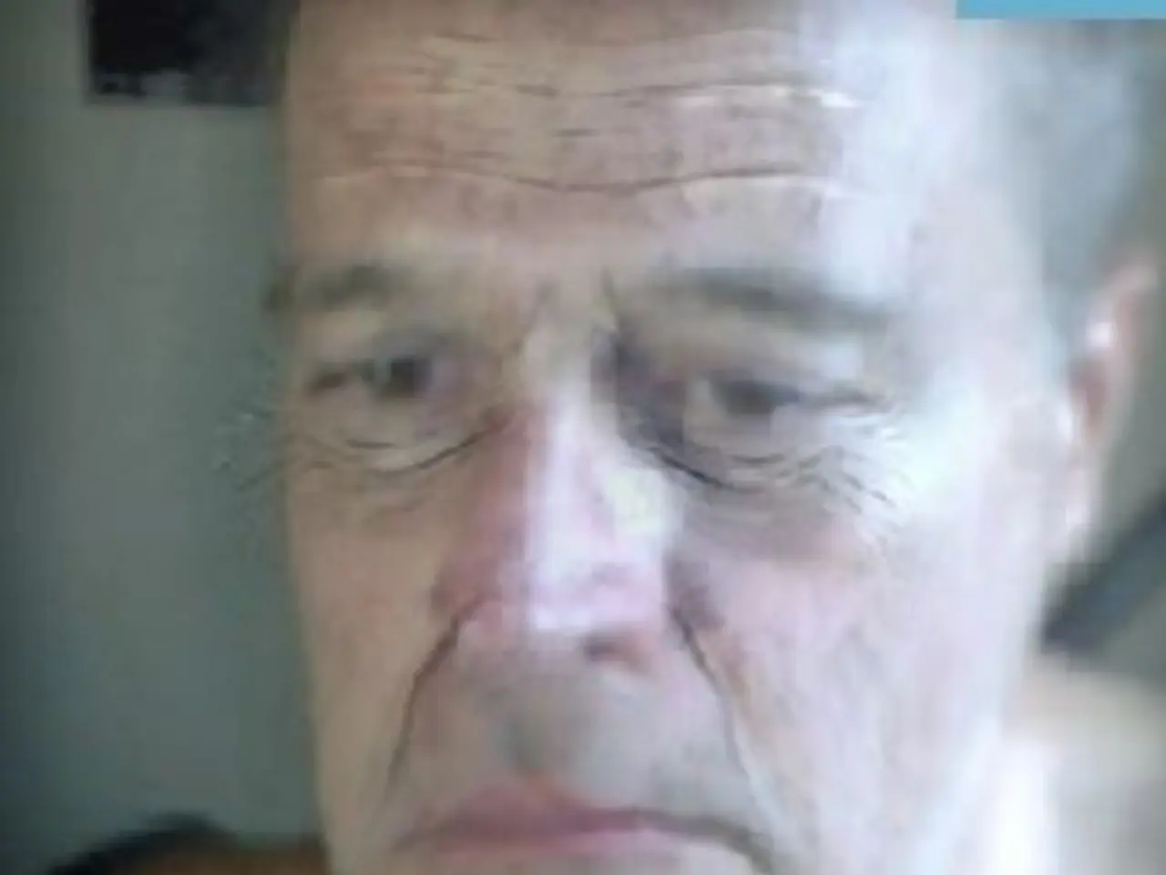 It is a blur image there is an old man, only his face is visible in the image.