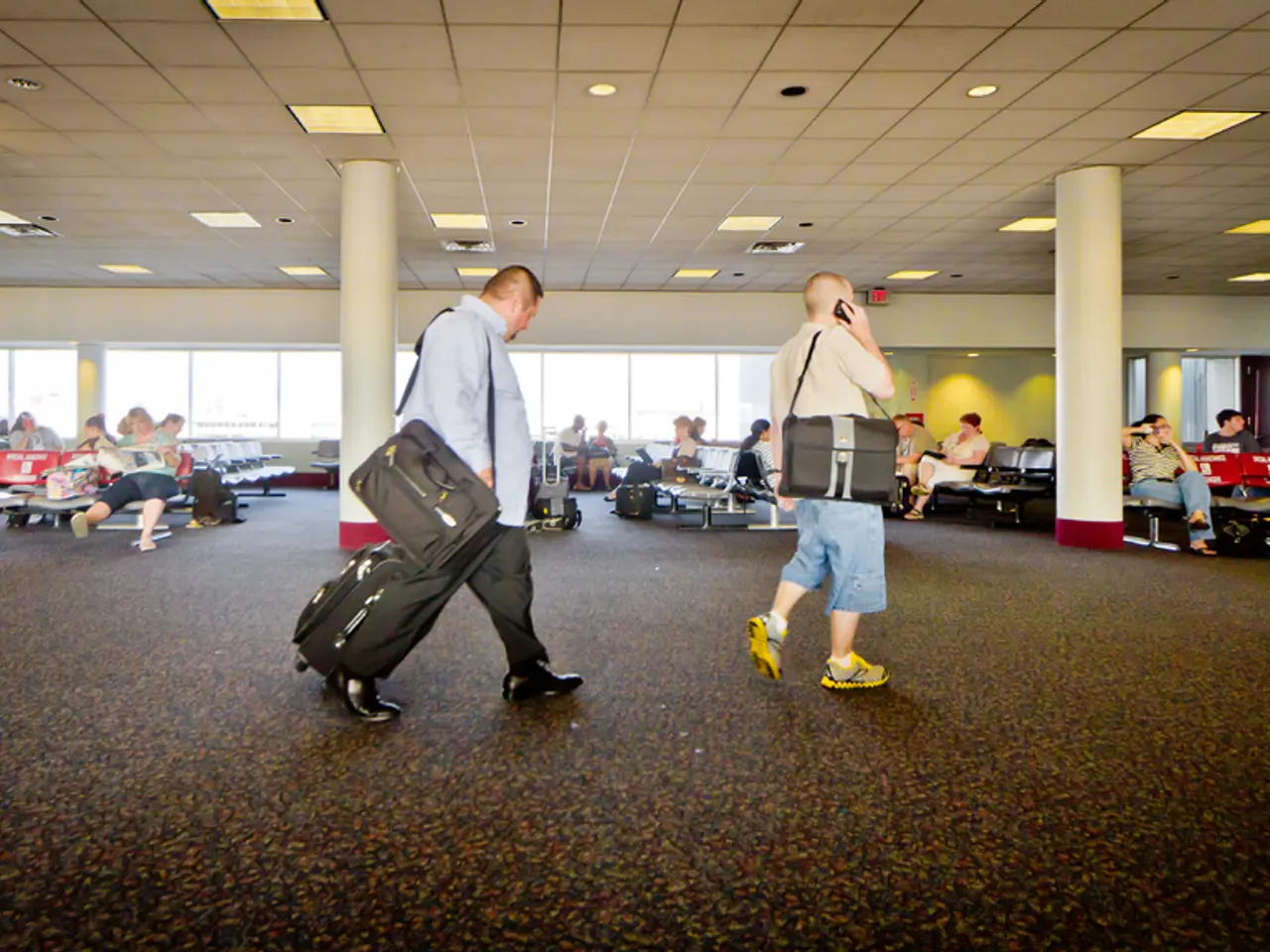 In the picture we can see an airport waiting hall with some people sitting on the chairs, and some...