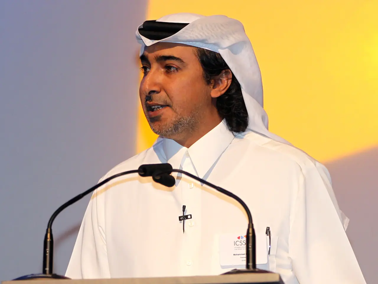 In this image there is a person standing on the dais in front of the mist is speaking.