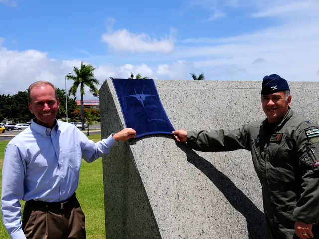 In this image, on the right there is a man, he is smiling, he is holding a flag. On the left there...
