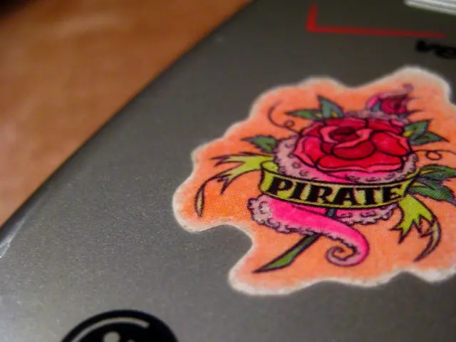 This image consists of a mobile on which there is a sticker. It is kept on a desk.