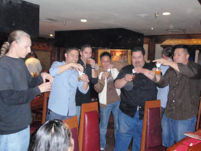 This image is clicked inside a room. There are so many persons in the middle. They are holding...