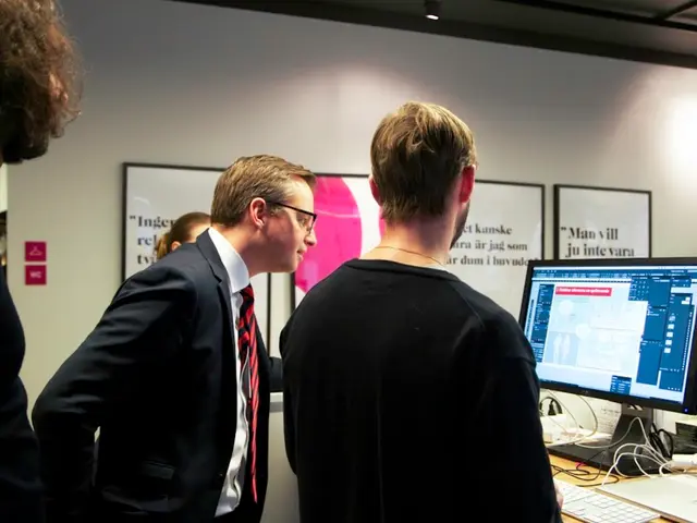 In this image we can see some group of persons standing near the computer and doing some work,...